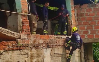 Grupo de bomberos en el barrio Villas de Girardot, haciendo control a un muro de un establecimiento que funciona como lechoneria, la zona es acordonada para evitar lesionados