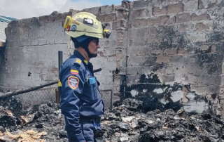 Bomberos inspeccionando los daños de un incendio en una empresa.
